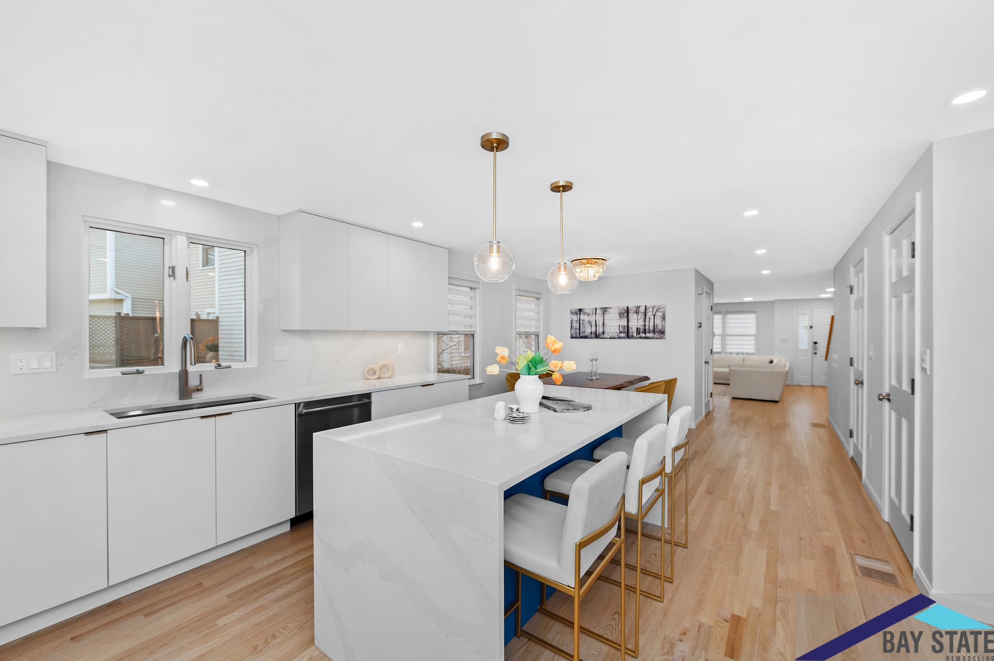 Completed kitchen remodel featuring white cabinetry, stainless steel appliances, hardwood flooring, and a black farmhouse sink.