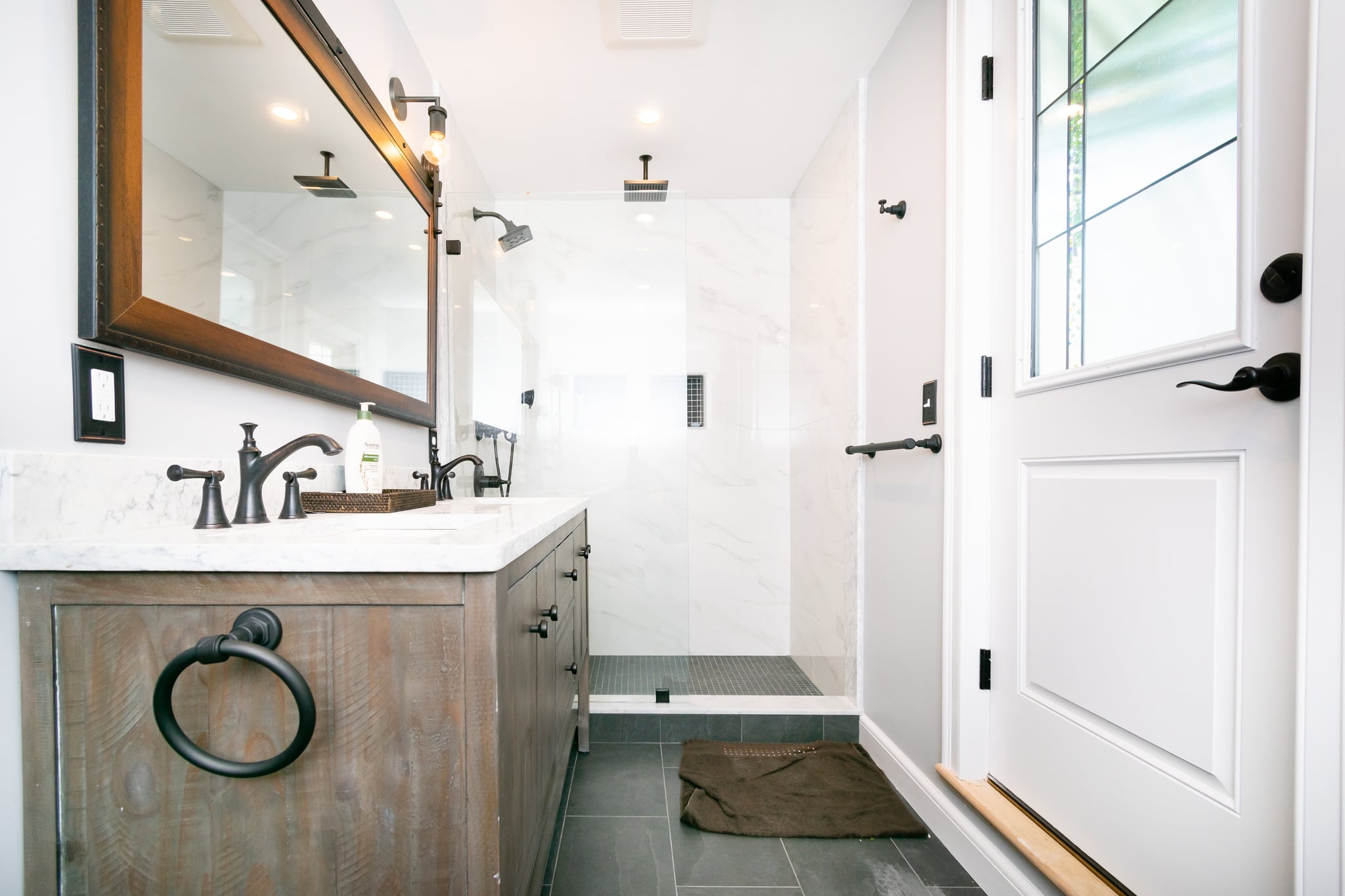 Small bathroom remodel ideas with white vanity, framed mirror, and tub-shower combo in a compact layout